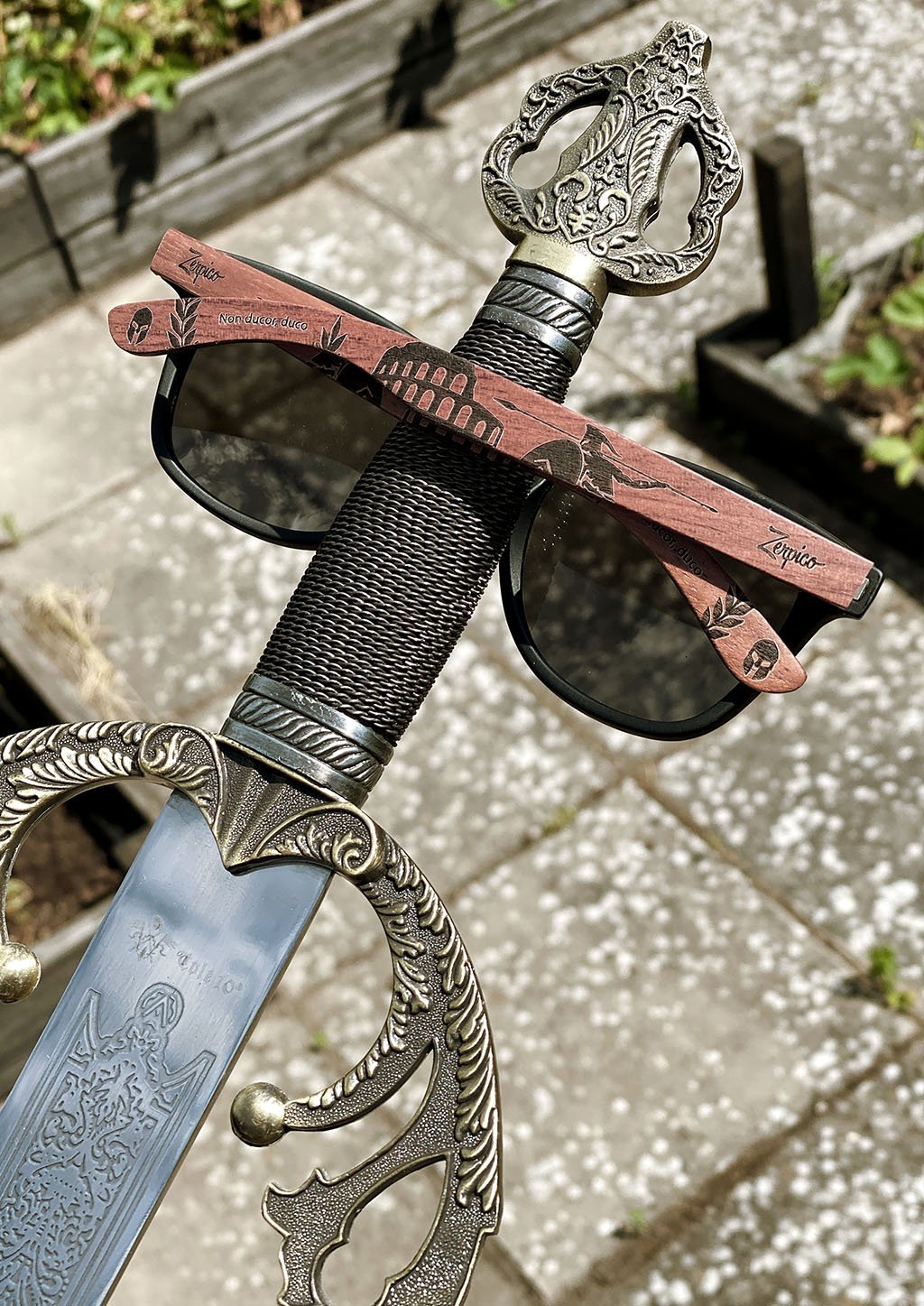 Zerpico GLADIATOR Eyewood Engraved Wooden Sunglasses - Pictured with a Gladiator Sword Highlighting Hand-Carved Wooden Arms