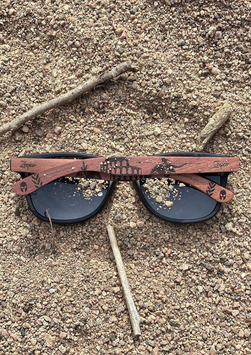 Zerpico GLADIATOR Eyewood Engraved Wooden Sunglasses -Folded In the Sand Highlighting Hand-Carved Wooden Arms